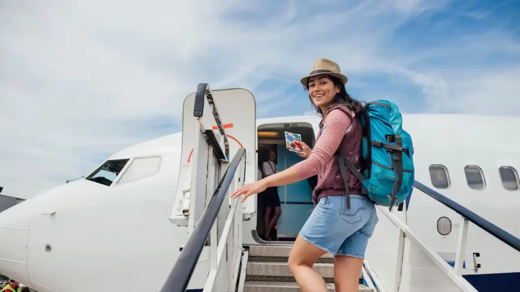Joven feliz subiendo a un avión porque sabe las claves para viajar con éxito