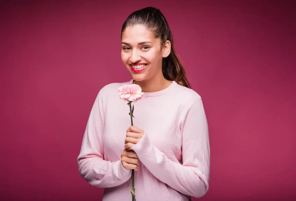 Chica morena posando con clavel